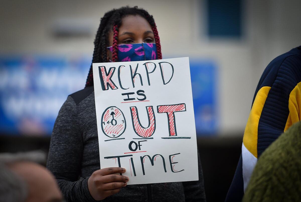 Rajahnai Calvin held a sign during a rally on Monday, Oct. 25, 2021, outside of the Unified Government offices to demand a Department of Justice investigation into Kansas City, Kansas police. Calvin is the niece of John Keith Calvin, who family members say is wrongly incarcerated.