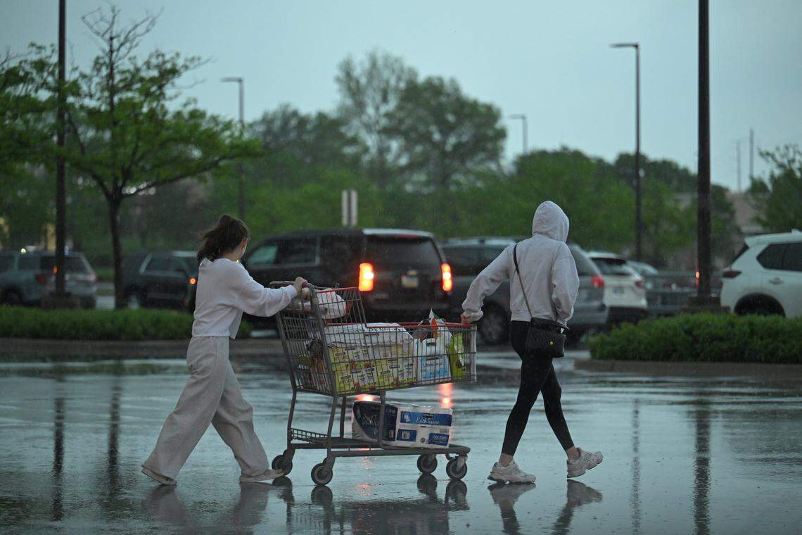 Costco shoppers rush through the parking lot as rain pours down on Friday, April 17, in Lenexa, Kansas.