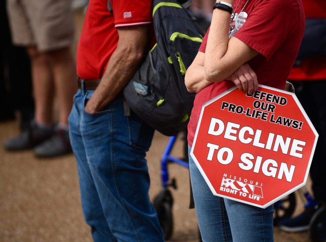 A woman holds a sign urging Missourians not to sign an abortion initiative petition at the Midwest March for Life on Wednesday at the Missouri State Capitol.