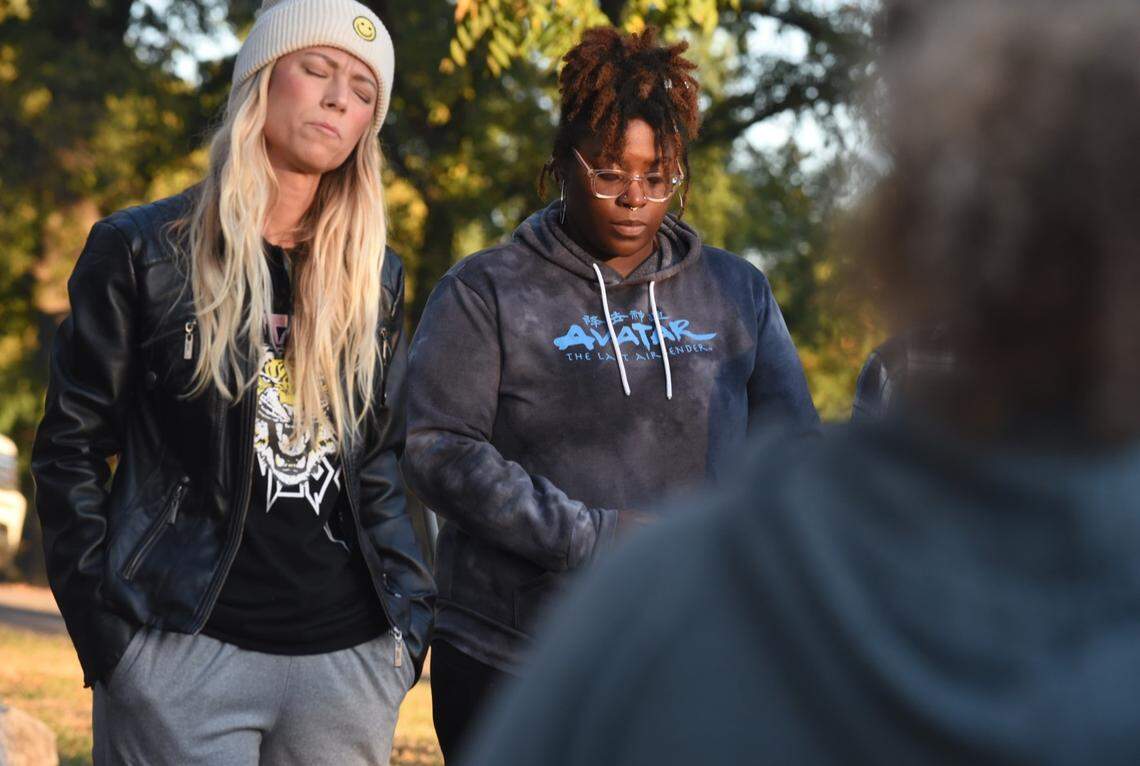 Excelsior Springs resident Sherie Renne, organizer of a local prayer vigil on Saturday, stands beside Yajieraka Chambers, also of the town, as roughly three dozen people gathered Saturday evening under a monument cross at Siloam Mountain Park to pray. The vigil was organized partly in response to a police investigation of a local man accused of kidnapping and rape, and possibly other crimes.