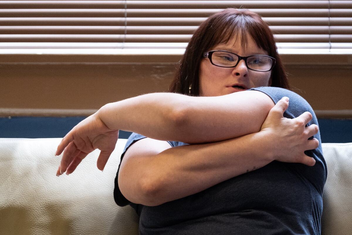 Randi McGaugh indicates where she was shot by a Jackson County deputy in 2019, while speaking in attorney Tim Porto’s Kansas City office on May 30, 2024.
