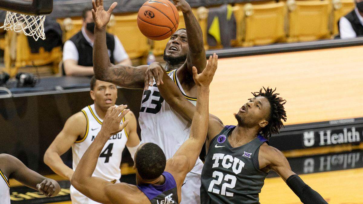 Missouri’s Jeremiah Tilmon, top, pulls down a rebound over TCU’s RJ Nembhard, right, and Jaedon LeDee, bottom, during overtime of an NCAA college basketball game Saturday, Jan. 30, 2021, in Columbia, Mo. Missouri won 102-98. (AP Photo/L.G. Patterson)