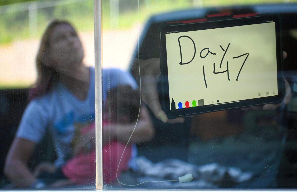 Gwen Starkey’s husband, Troy, posted a sign in her hospital room Thursday noting 147 days of battling COVID-19.