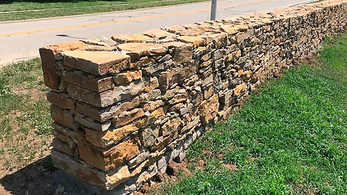 The original stone wall has been carefully rebuilt to honor the property’s history.