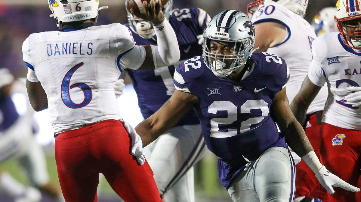 Kansas Jayhawks quarterback Jalon Daniels (6) is pressured by Kansas State Wildcats linebacker Daniel Green (22) during the fourth quarter at Bill Snyder Family Football Stadium on Nov. 26, 2022.
