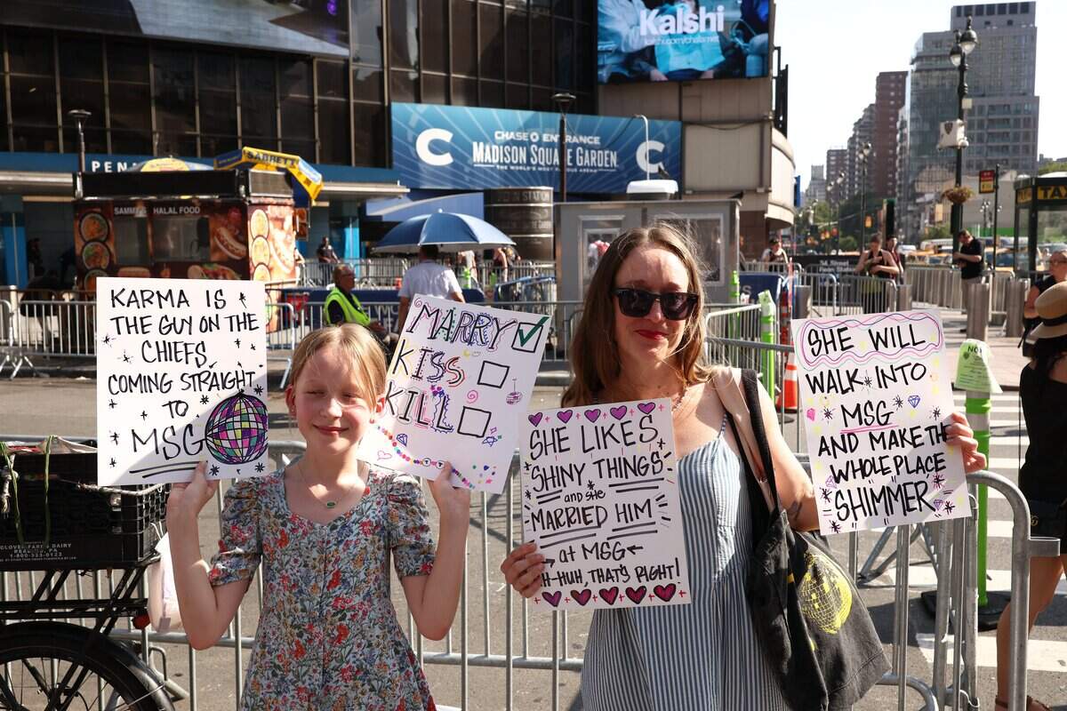 Taylor Swift fans hold signs outside Madison Square Garden, the reported venue for the wedding celebrations of pop singer Taylor Swift and pro-athlete Travis Kelce, in New York City on July 3, 2026. Swift and Kelce's official wedding plans are tightly under wraps, but New York is bracing to host the celebrity marriage of the year this week at Madison Square Garden. The wedding will reportedly take place Friday with a star-studded guest list of around 1,000, including models Gigi Hadid and Cara Delevingne, singer Selena Gomez, and actress Zoe Kravitz -- all known to be close Swift pals -- and Kelce's Kansas City Chiefs teammates. (Photo by CHARLY TRIBALLEAU / AFP via Getty Images)