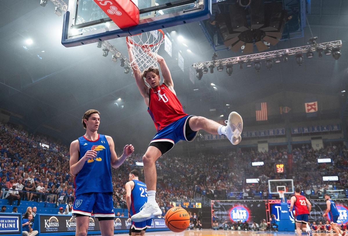 Johnny Furphy hangs from the rim after dunking during Late Night in the Phog on Friday, Oct. 6, 2023, at Allen Fieldhouse in Lawrence.