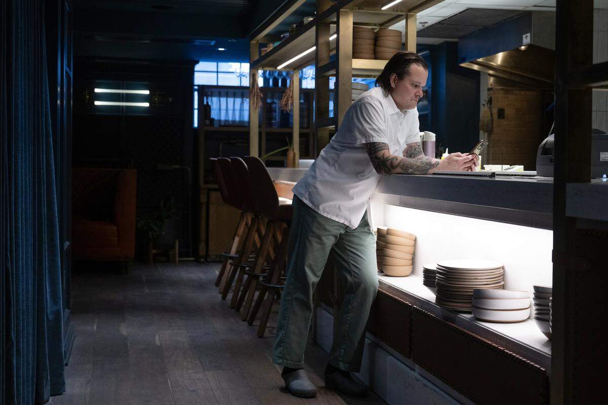 Executive Chef Johnny Leach of The Town Company checks his phone on Wednesday, March 18, 2026, after arriving at the restaurant located at Hotel Kansas City. Leach is nominated for a James Beard Foundation award. 