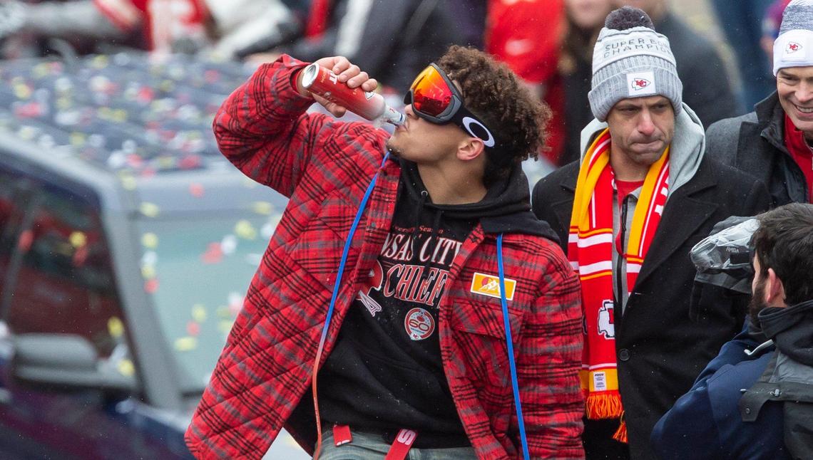Kansas City Chiefs quarterback Patrick Mahomes has a celebratory beer while riding down Grand Boulevard in the Super Bowl victory parade Wednesday.