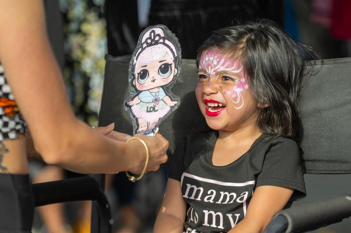 Four-year-old Milani Lara sees herself for the first time in the mirror after getting her face painted at the First Fridays Under the Bridge festival.