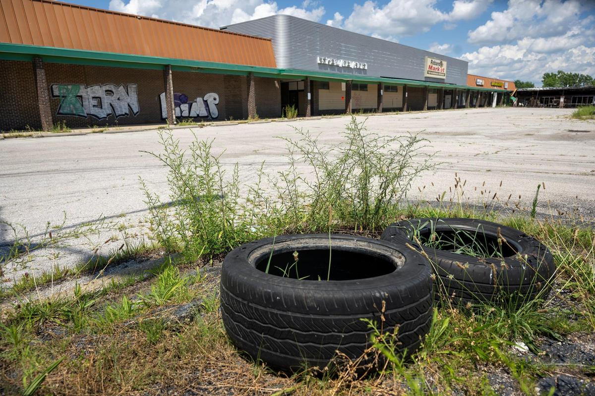 Weeds sprout around discarded tires in the parking lot of the derelict and empty Robandee Shopping Center, located at 8300 E. Bannister Rd. in Kansas City, on Monday, July 7, 2025.