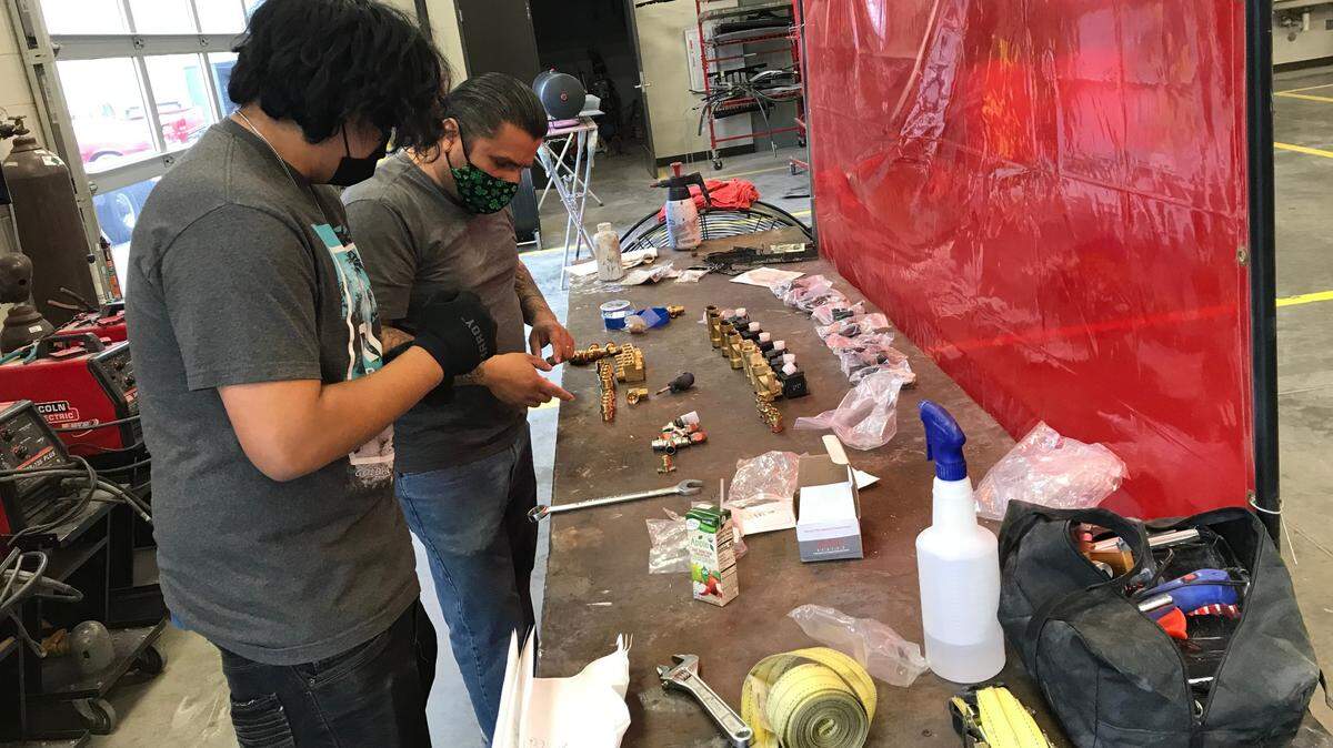 Alex Mendoza works with Lowrider Bike Club founder Erik Erazo on a project.