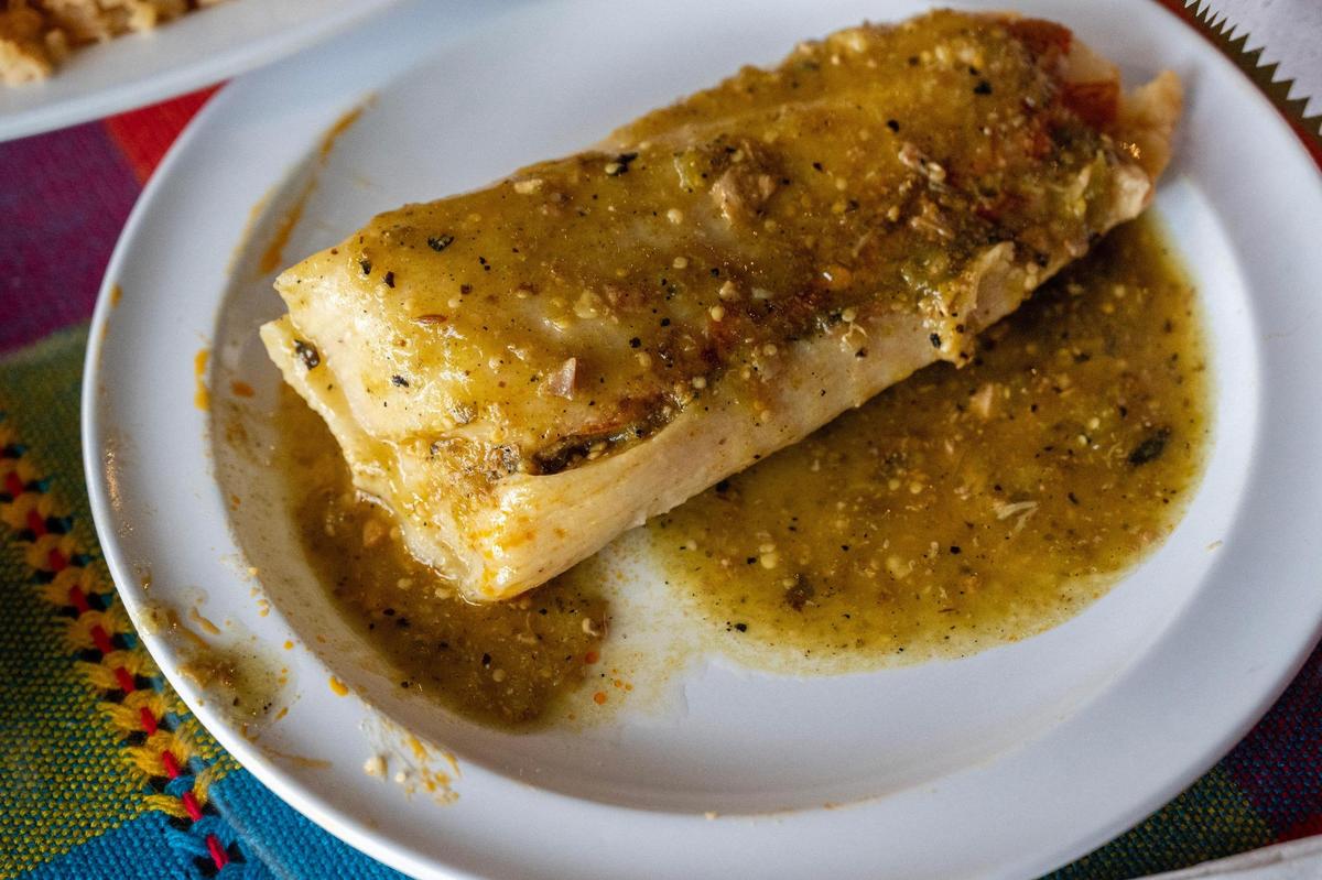 A tamale bathed in a house-made sauce is served as a side at Los Alamos Cocina.