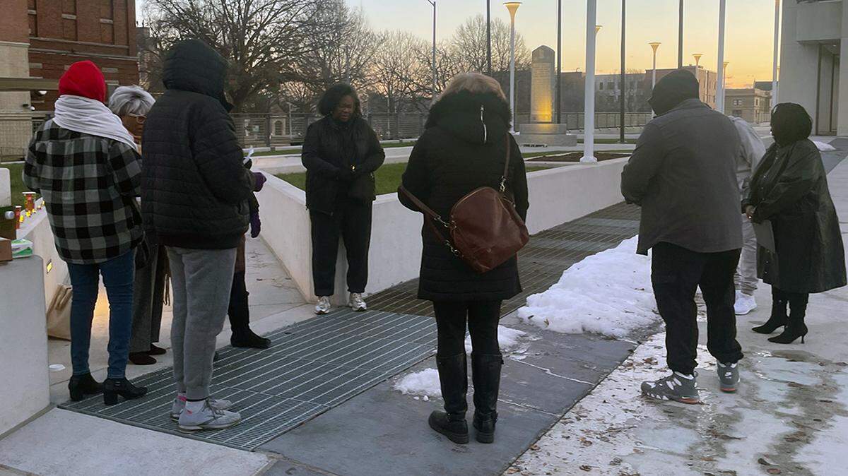 People affected by former KCK police detective Roger Golubski say an opening prayer ahead of their demonstration on the morning of Dec. 9, 2025.