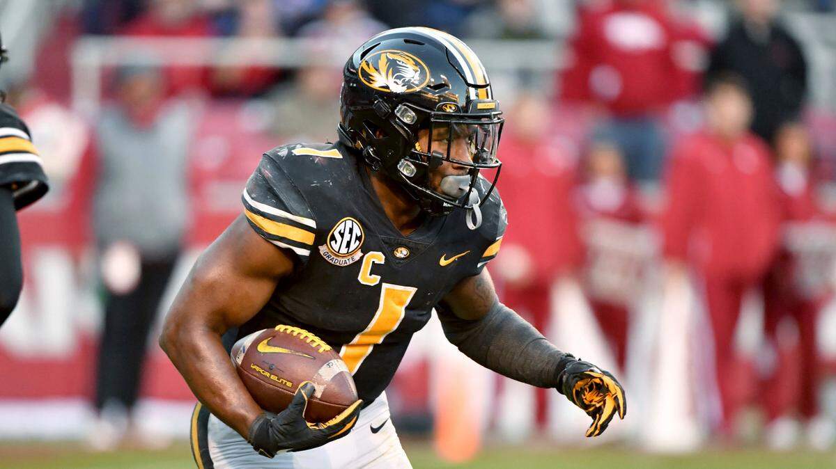 Missouri running back Tyler Badie (1) runs the ball against Arkansas during the second half of an NCAA college football game Friday, Nov. 26, 2021, in Fayetteville, Ark. (AP Photo/Michael Woods)