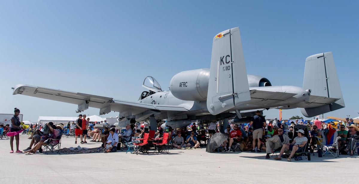 Dozens of people find relief from the sun in the shadow of an A-10 Thunderbolt during the Garmin KC Air Show on Saturday, Aug. 19, 2023, in New Century.