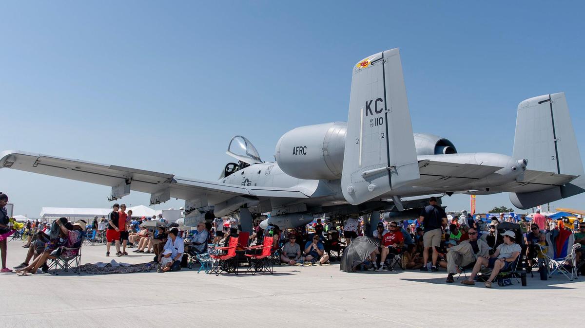 Dozens of people find relief from the sun in the shadow of an A-10 Thunderbolt during the Garmin KC Air Show on Saturday, Aug. 19, 2023, in New Century.