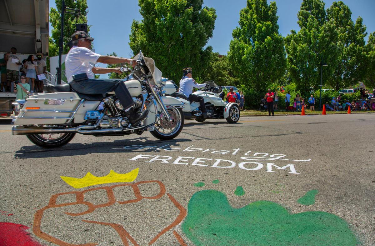 Parade participants passed by chalk art during the JuneteenthKC 2021 Cultural Parade Saturday, June 12, 2021 in the Historic Jazz District near 18th and Vine.
