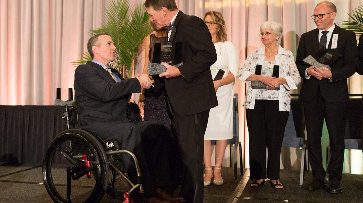 Phil Hanson, president and CEO of Truman Heartland Community Foundation, awards Dr. Jay Rapley.
