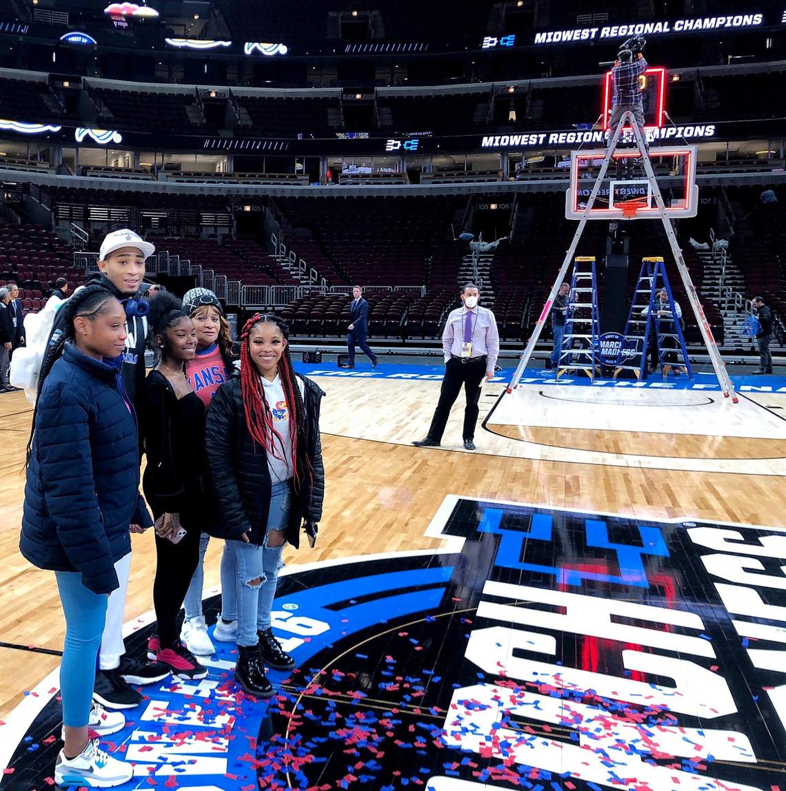 Kansas guard Dajuan Harris poses for photos on the United Center court with mother Demetria Roland, left, and other family members following KU’s 76-50 victory over Miami in Chicago. The win advanced the Jayhawks to the Final Four.