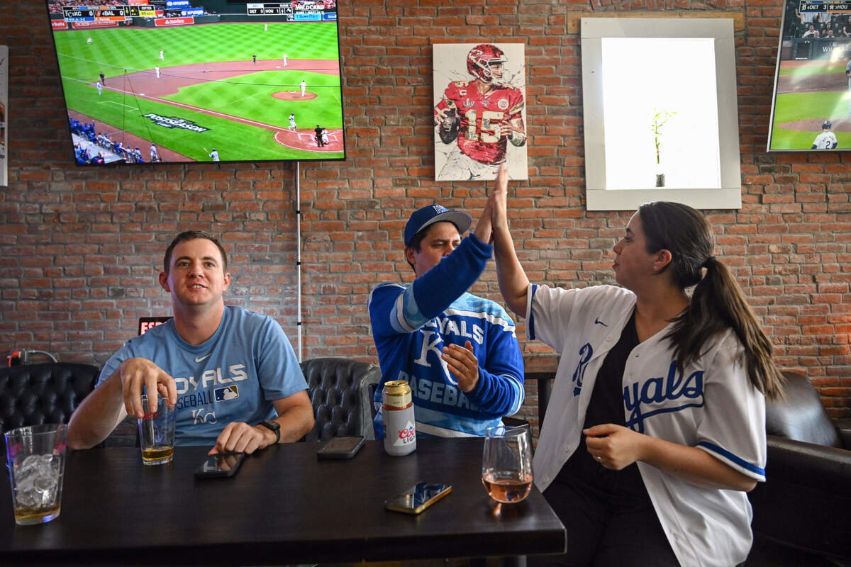 Kevin Walterbach, of North Kansas City, left, watched as Kevin and Jen O’Brien of Kansas City, Kansas, high five after the Kansas City Royals scored on an RBI by Bobby Witt Jr. during the AL Wild Card game with the Baltimore Orioles, Tuesday, Oct. 1, 2024, at The Davenport sports bar in Kansas City, Kansas.