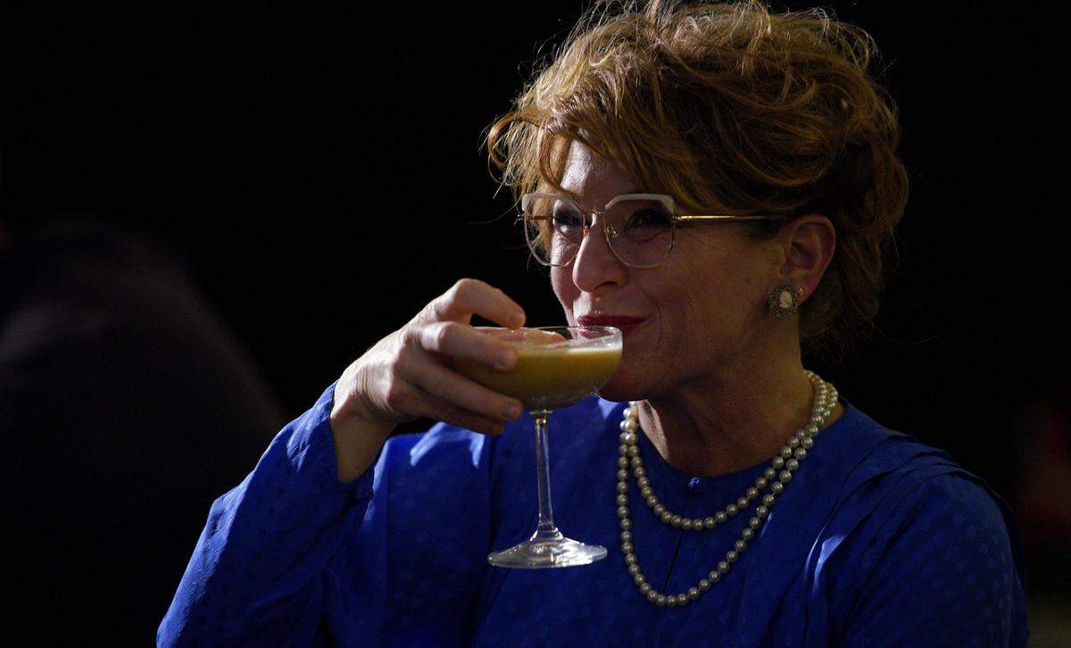 Heather Hamilton, in a wig for the occasion, takes a sip from a cocktail during a “Golden Girls Night” at the bar, when fans and regulars watch the show and occasionally dress up as the characters.