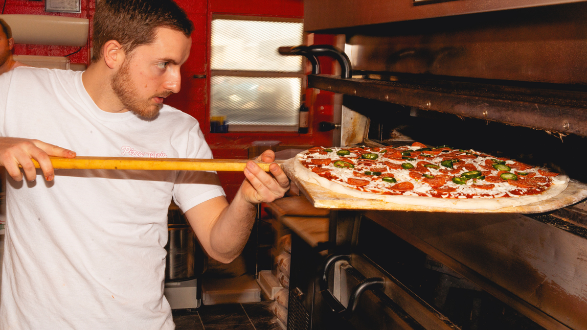 Gian Lombardino slides a Spicy Pepperoni pie into a Pizza Tascio oven.