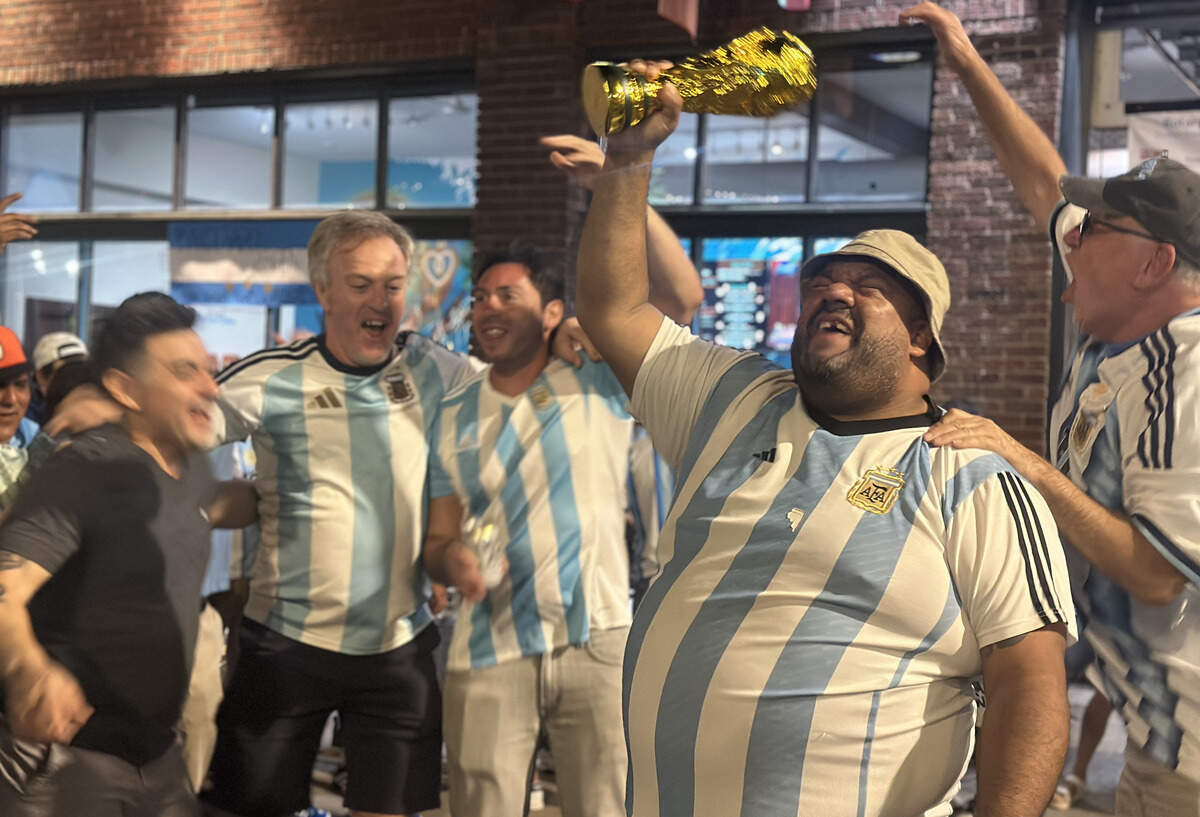 At the end of the night, an Argentinian fan belts out to the song while holding a World Cup trophy. Dozens of fans danced and jumped together in the street to finish the event.