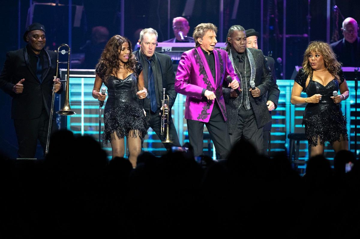 Barry Manilow performs on stage with his backup singers at the T-Mobile Center Sunday during a stop in Kansas City as part of The Last Concerts Tour.