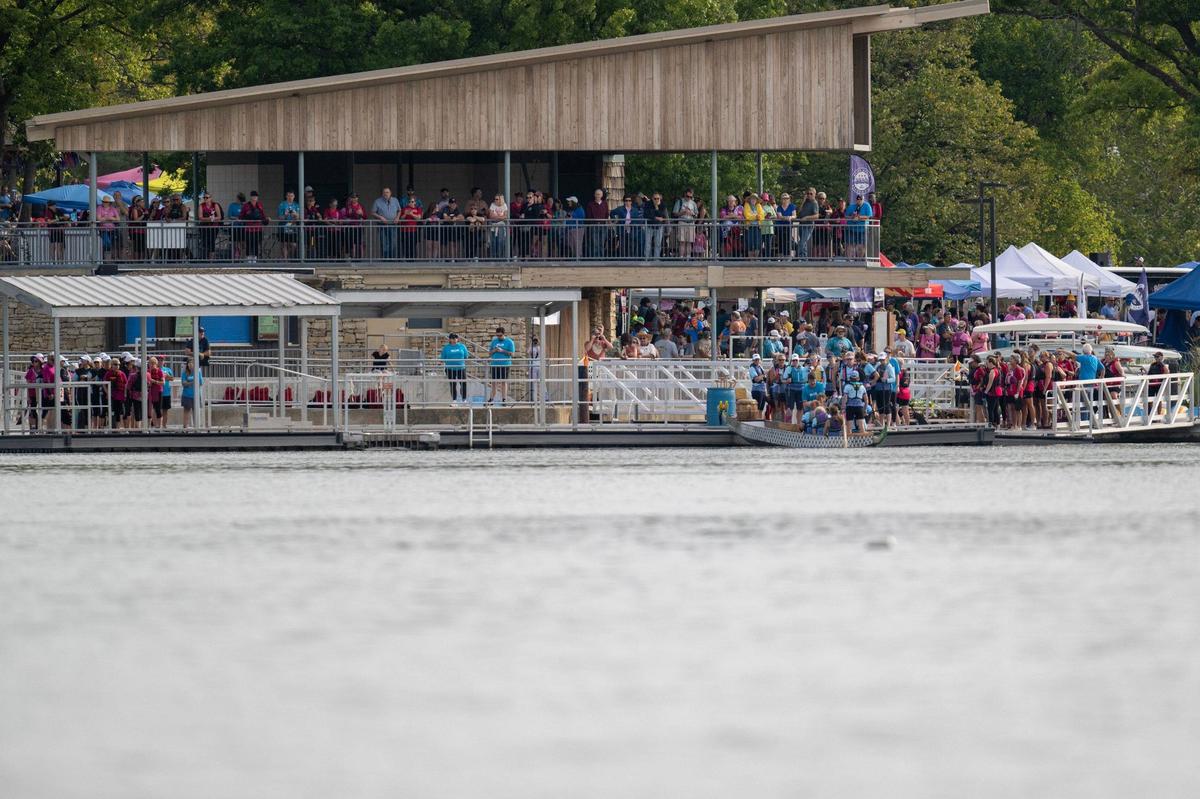 Spectators watch from the dock as crew members board their boats during the KC Dragon Boat Festival on Saturday, Sept. 28, 2024, at Shawnee Mission Park.