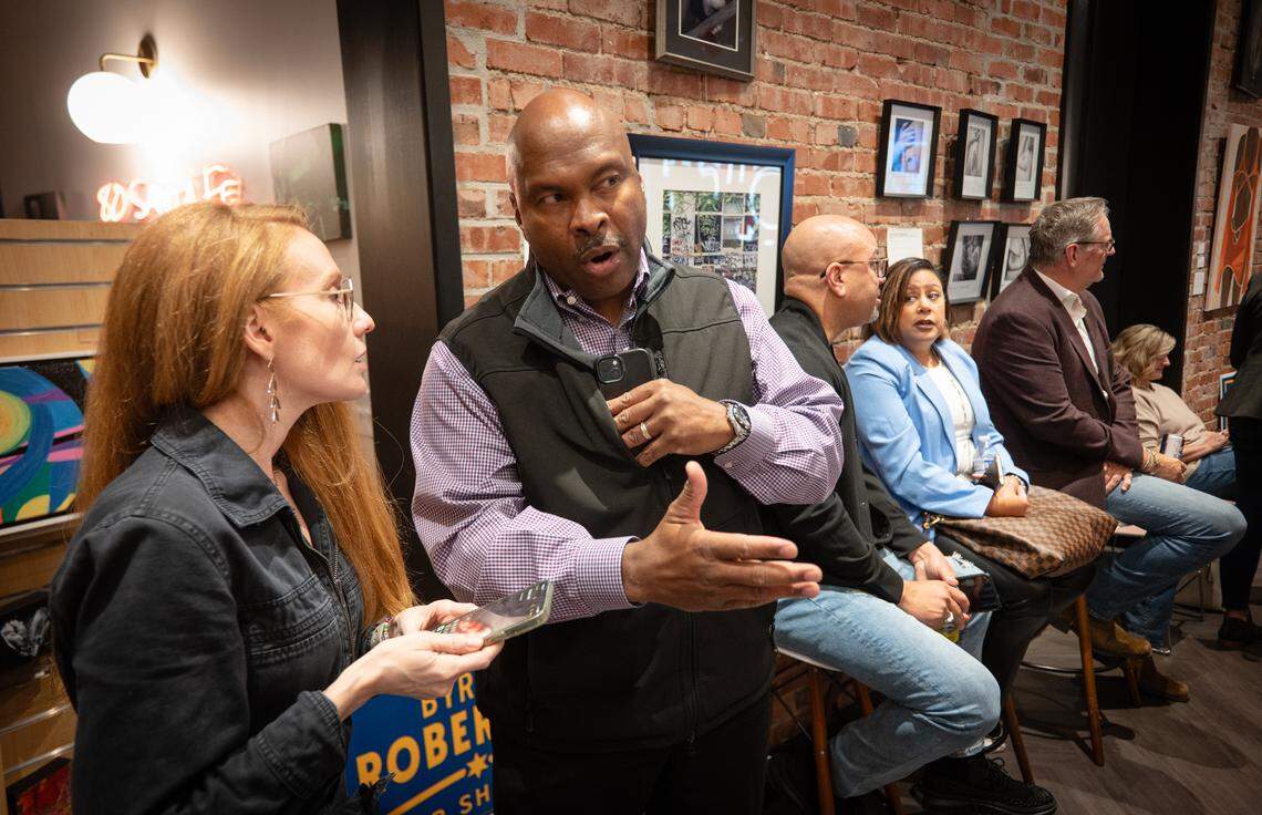 Democratic Party candidate for Johnson County Sheriff Byron Roberson talks to campaign assistant Jennifer Winfrey at an election night watch party on Tuesday, Nov. 5, 2024, in downtown Overland Park.