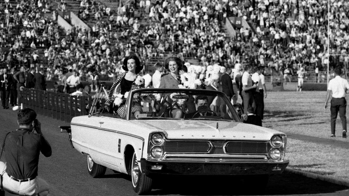 Homecoming queen candidates from 1965 parade around the track inside KU's Memorial Stadium.
