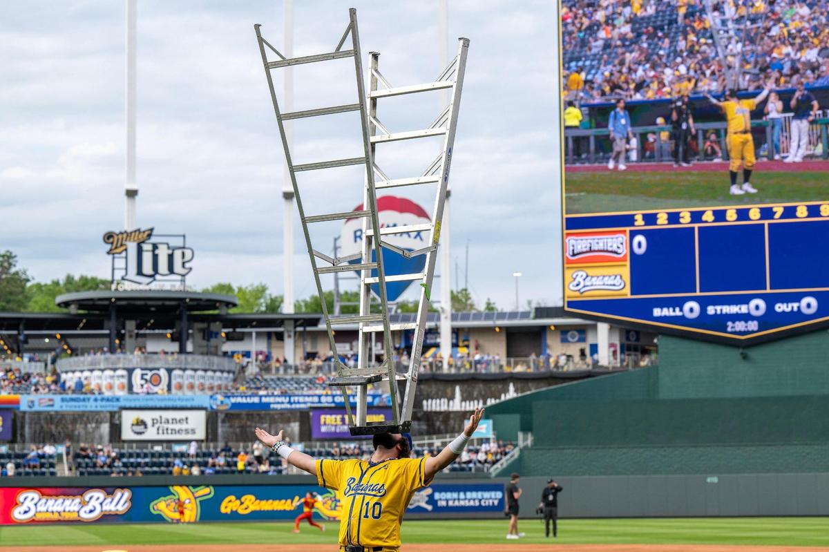 Savannah Bananas extra hitter Alex Ziegler (10) balances a ladder during a pregame activity before a Banana Ball game against the Firefighters at Kauffman Stadium on Friday, May 23, 2025, in Kansas City.