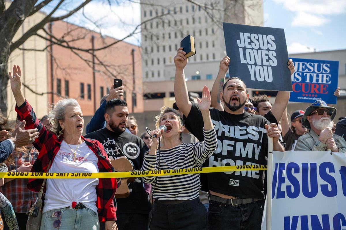 Counter-demonstrators stand behind yellow caution tape as attendees participate in the Satanic Grotto’s Black Mass ritual at the Kansas State Capitol on Friday, March 28, 2025, in Topeka.