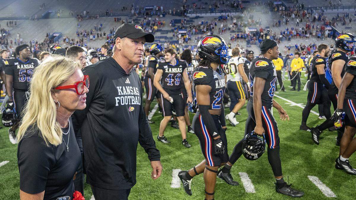 Kansas coach Lance Leipold leaves the field with his wife, Kelly, after the Jayhawks defeated the West Virginia Mountaineers 41-10 at David Booth Kansas Memorial Stadium on Saturday, Sept. 20, 2025, in Lawrence.