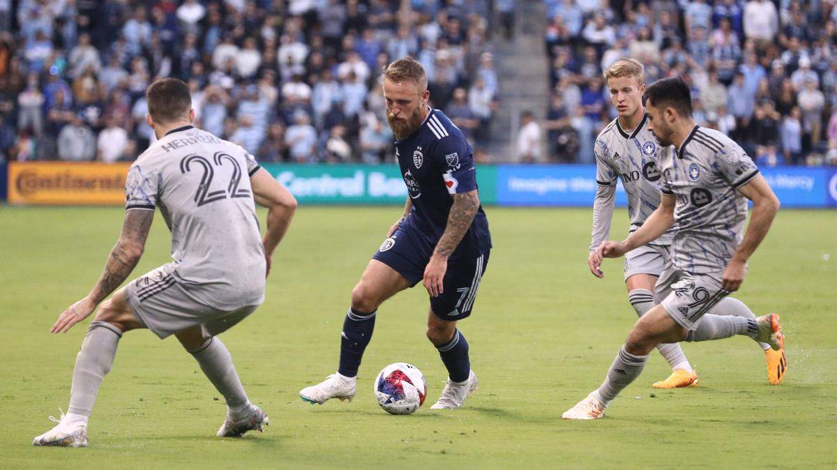 Sporting Kansas City forward Johnny Russell (7) dribbles the ball against CF Montreal defender Aaron Herrera (22) and midfielder Mathieu Choiniere (29) at Children’s Mercy Park on April 29, 2023.