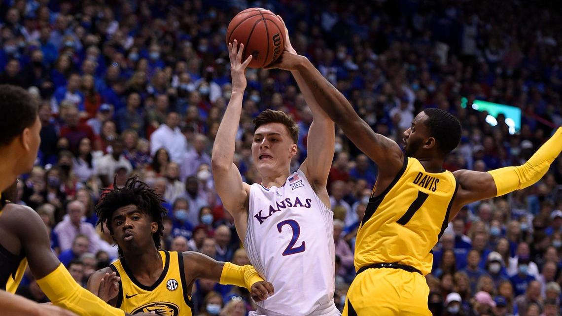 KU’s Christian Braun drives between MU’s Anton Brookshire (left) and Amari Davis during the first half on Saturday at Allen Fieldhouse (Dec. 11, 2021)..