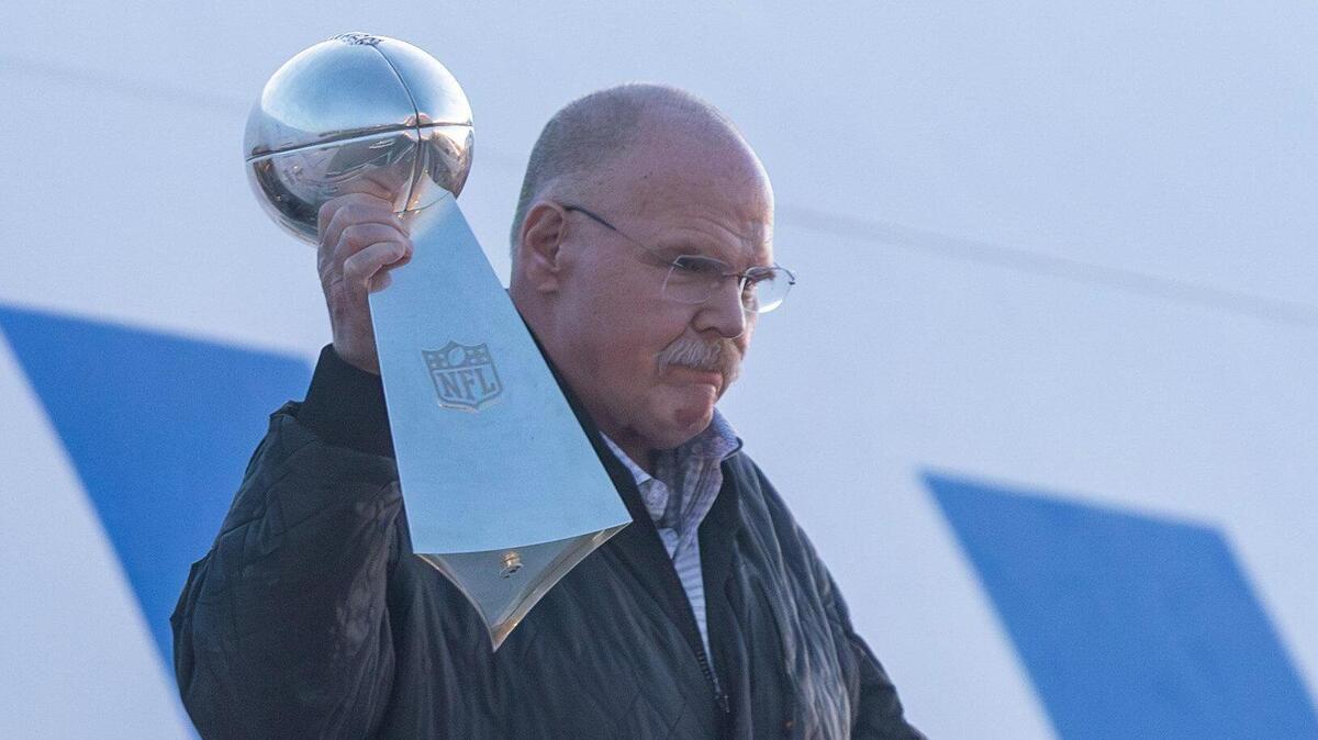 Kansas City Chiefs’ head coach Andy Reid holds the Lombardi Trophy as he steps off the team’s charter plane at Kansas City International Airport on Tuesday.