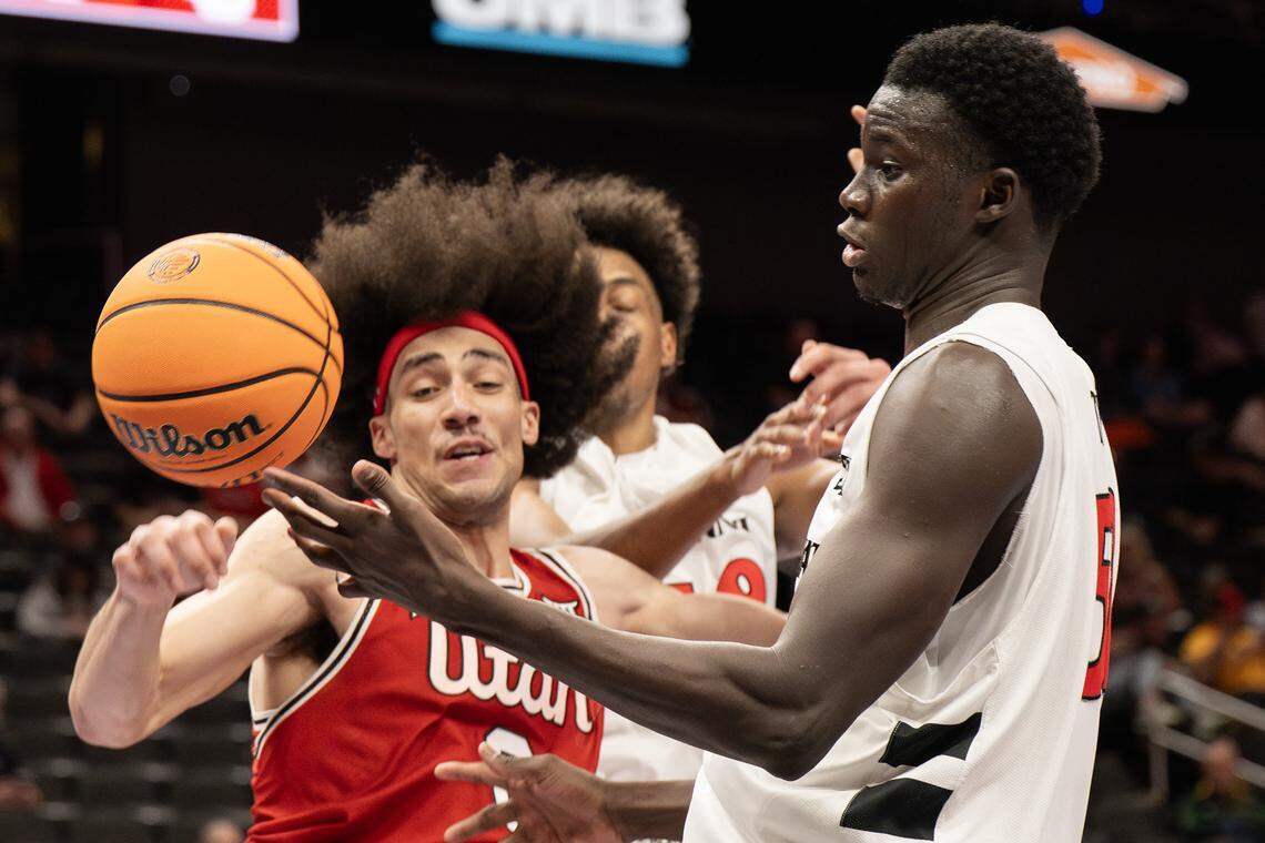 Cincinnati center Moustapha Thiam (52) and Utah forward Keanu Dawes (8) battle for possession during the second half of a Big 12 men's basketball tournament game at T-Mobile Center on Tuesday, March 10, 2026, in Kansas City, Mo.