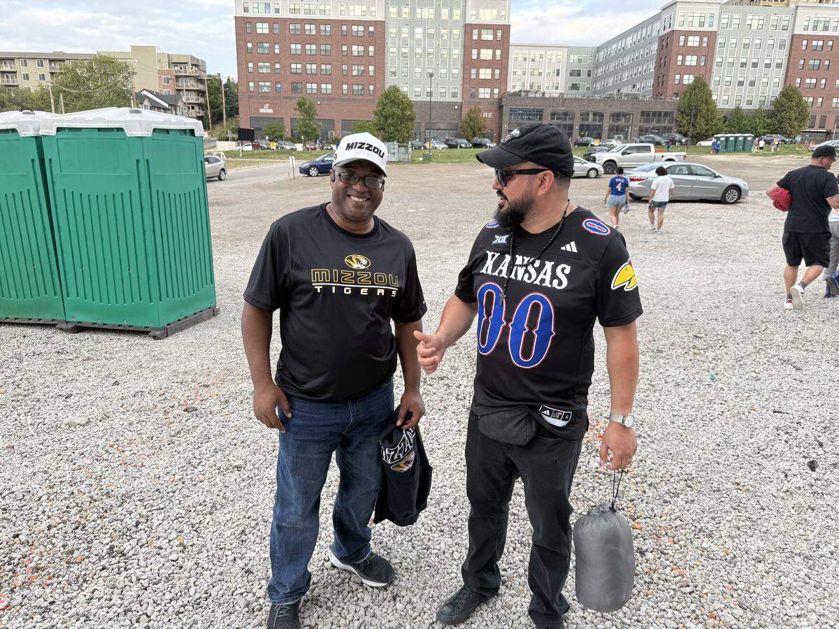 At least one Missouri fan attended the KU-MU watch party on Saturday at David Booth Kansas Memorial Stadium. Here, Theodore Burtin of Kansas City visits with a KU fan on the way to their vehicles after the contest, which was shown on the big screen.