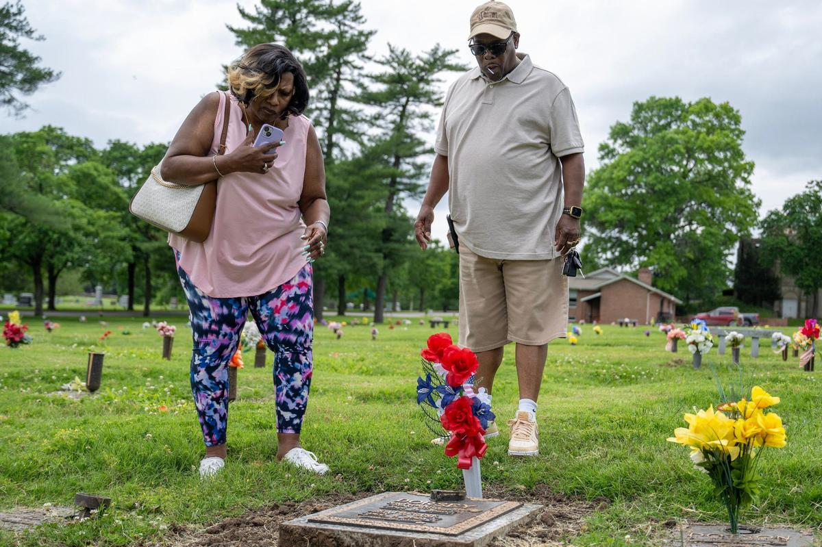 Patricia Howard, left, and her husband Ernest, pay a visit to his parents’ grave at Forest Hill Calvary Cemetery in Kansas City on Friday, May 24, 2024. They place flowers to honor her husband’s father, who was a Marine Corps veteran.
