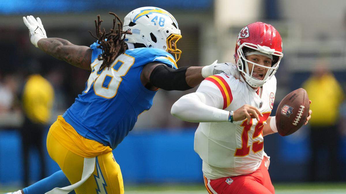 Kansas City Chiefs quarterback Patrick Mahomes (15) carries the ball against Los Angeles Chargers linebacker Bud Dupree (48) in the second quarter at SoFi Stadium.