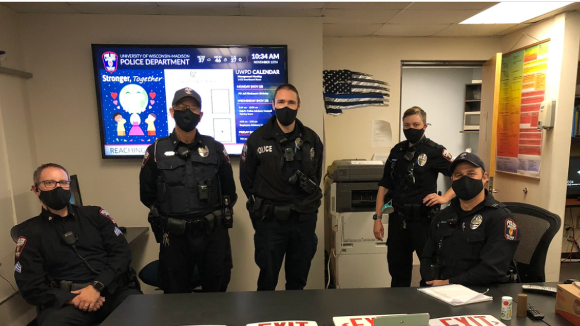 The University of Madison-Wisconsin Police Department posted this photo in which a “thin blue line” flag can be seen in the background, angering some in the community who demanded its removal.