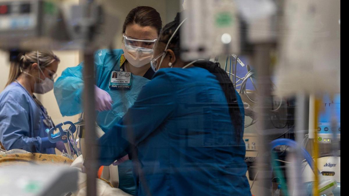 Allyse Dowell, center, a registered nurse at Saint Luke’s Hospital of Kansas City, and her colleagues care for a COVID-19 patient in ICU. COVID patients are needing intensive care longer than other ICU patients.