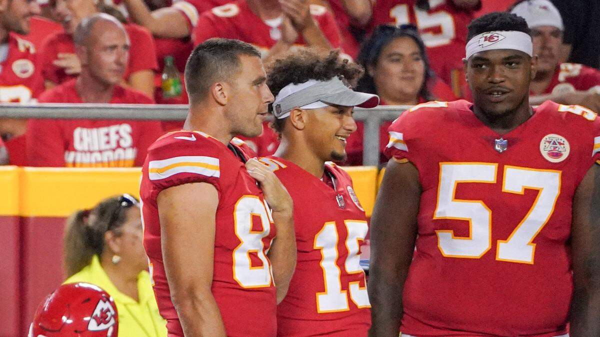 Aug 27, 2021; Kansas City, Missouri, USA; Kansas City Chiefs tight end Travis Kelce (87) and quarterback Patrick Mahomes (15) and offensive tackle Orlando Brown (57) watch play on the sidelines against the Minnesota Vikings during the game at GEHA Field at Arrowhead Stadium. Mandatory Credit: Denny Medley-USA TODAY Sports