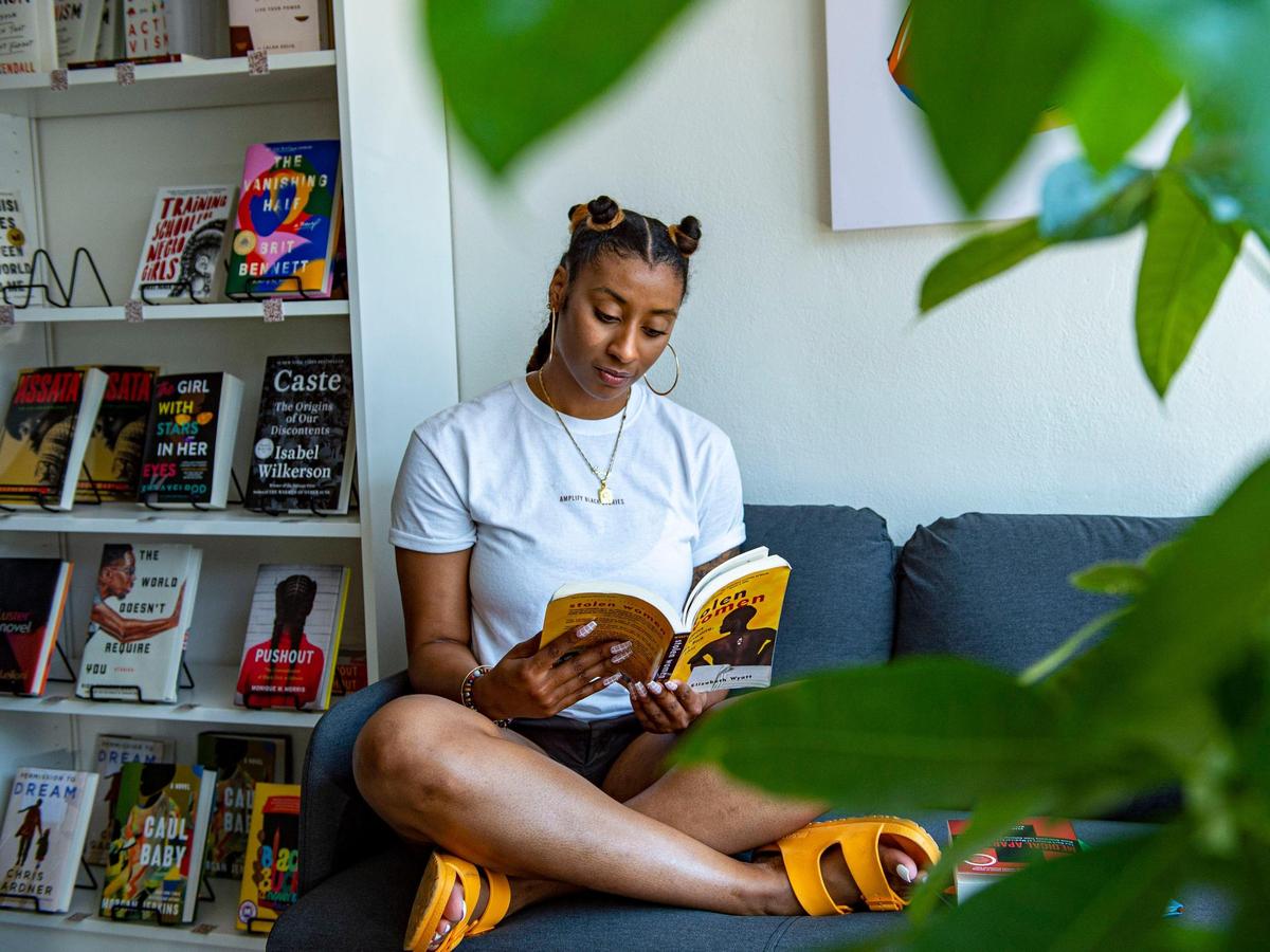 Cori Smith sits in her new bookstore BLK + BRWN, Friday, June 18, 2021, in Kansas City, Mo. “I always was surrounded by Black and brown literature. And so I always was just very interested in Black books, Black authors, stories about people that look like me. And so that’s kind of been steadfast throughout my life,” Smith said. The store will open Saturday, June 19, 2021.