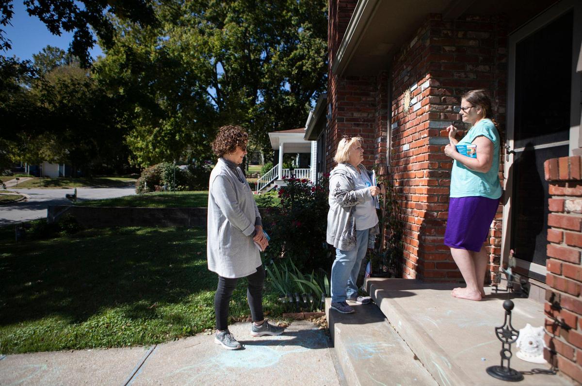 Backed by her friend Jan Bombeck, Diane Kehres, center, speaks to De Soto resident Ann Pennington while campaigning for city council. After volunteering for Sharice Davids’ campaign last year, Kehres decided to run for city council. She wants to see more women represented in her city government.