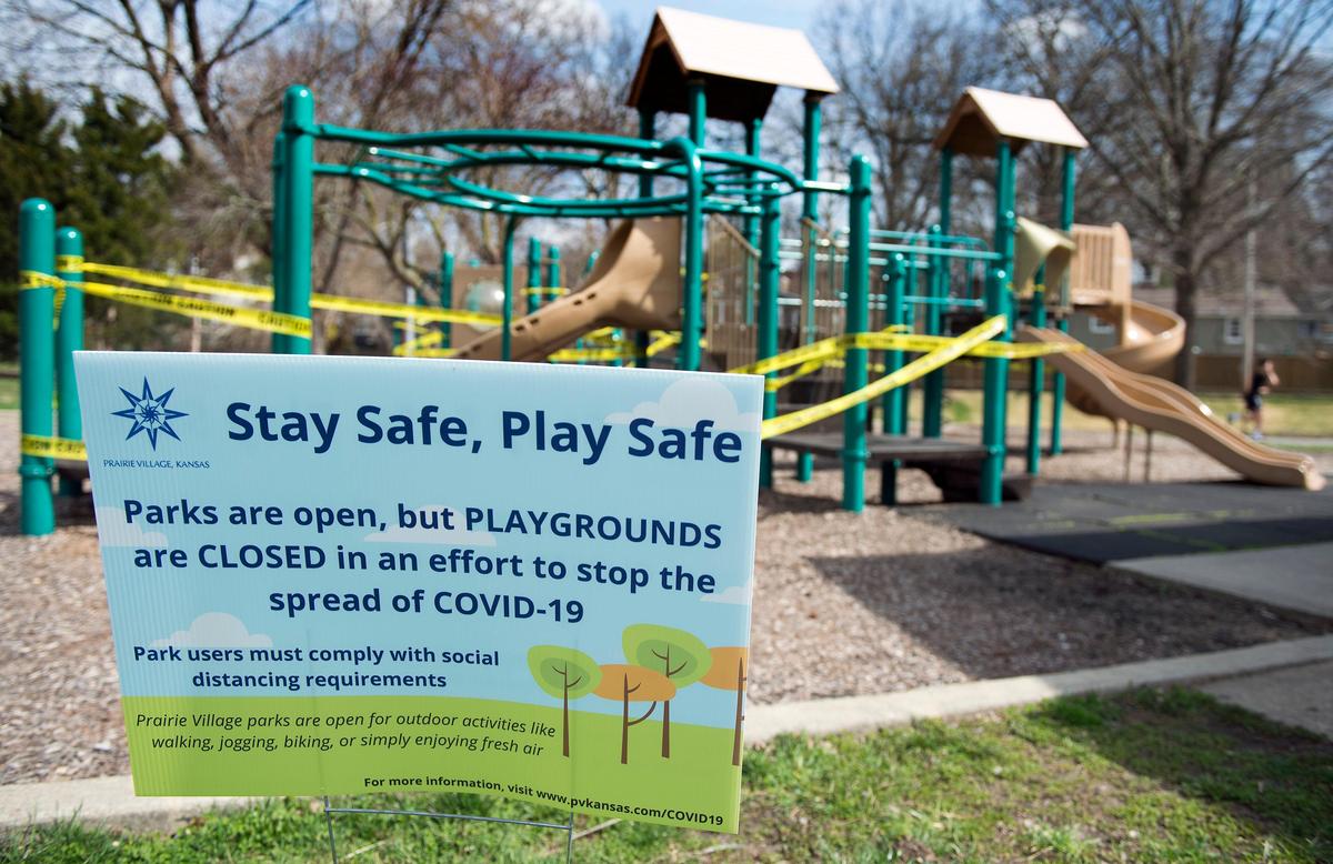 Signage at Porter Park in Prairie Village tells residents that the park is open, but the playgrounds are closed in an effort to stop the spread of COVID-19.