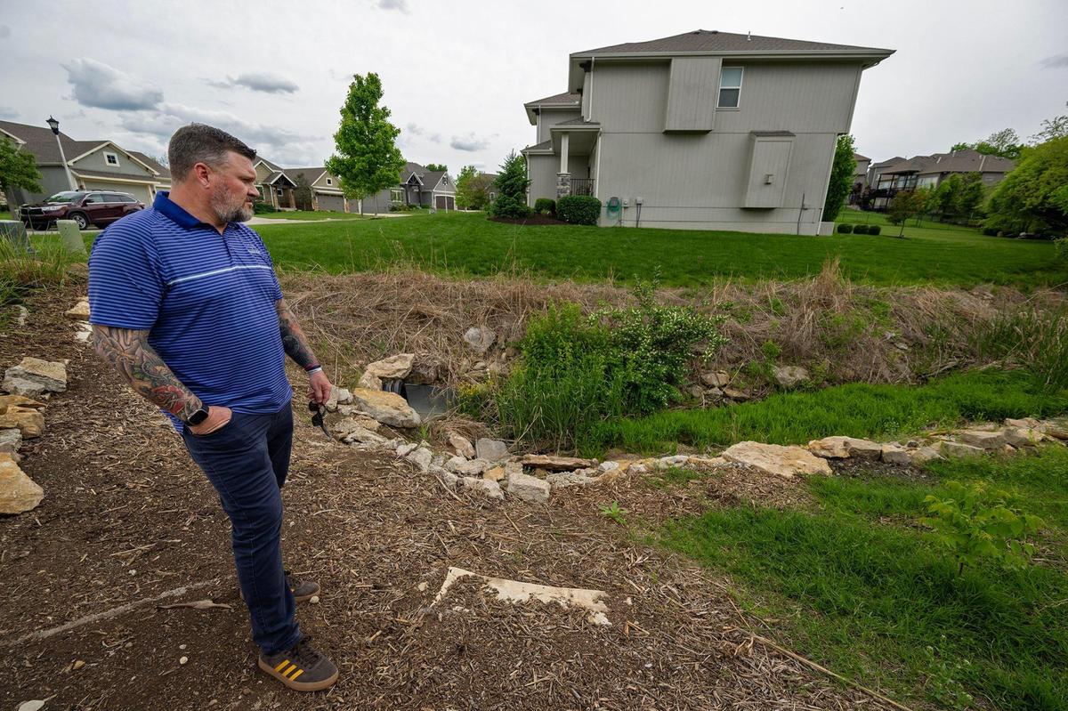 Max Cook, who lives in the College Meadows neighborhood in Olathe, has concerns about a small storm water drain which was over whelmed with runoff in 2021 and flooded his home, right, seen here on May 6.