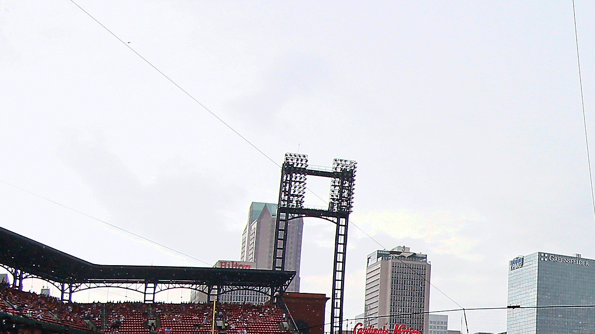 Fans wait out a rain delay before Sunday's baseball game between the Cardinals and the Royals at Busch Stadium. The game later was postponed.